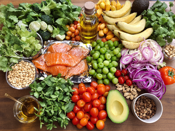 Heart-healthy foods arrangement including salmon, avocados, nuts, and vegetables